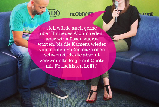 Eine Reporterin möchte einen Künstler interviewen. Die Kamera zeigt allerdings ihre Füße, was sie zynisch kommentiert.