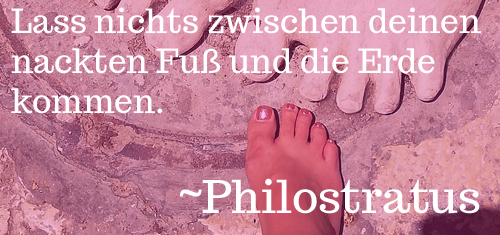 Ein nackter Fuß und die steinernen Füße einer Statue. Es ist ein Text darüber gelegt mit einem Zitat von Philostratus über die Schönheit nackter Füße.